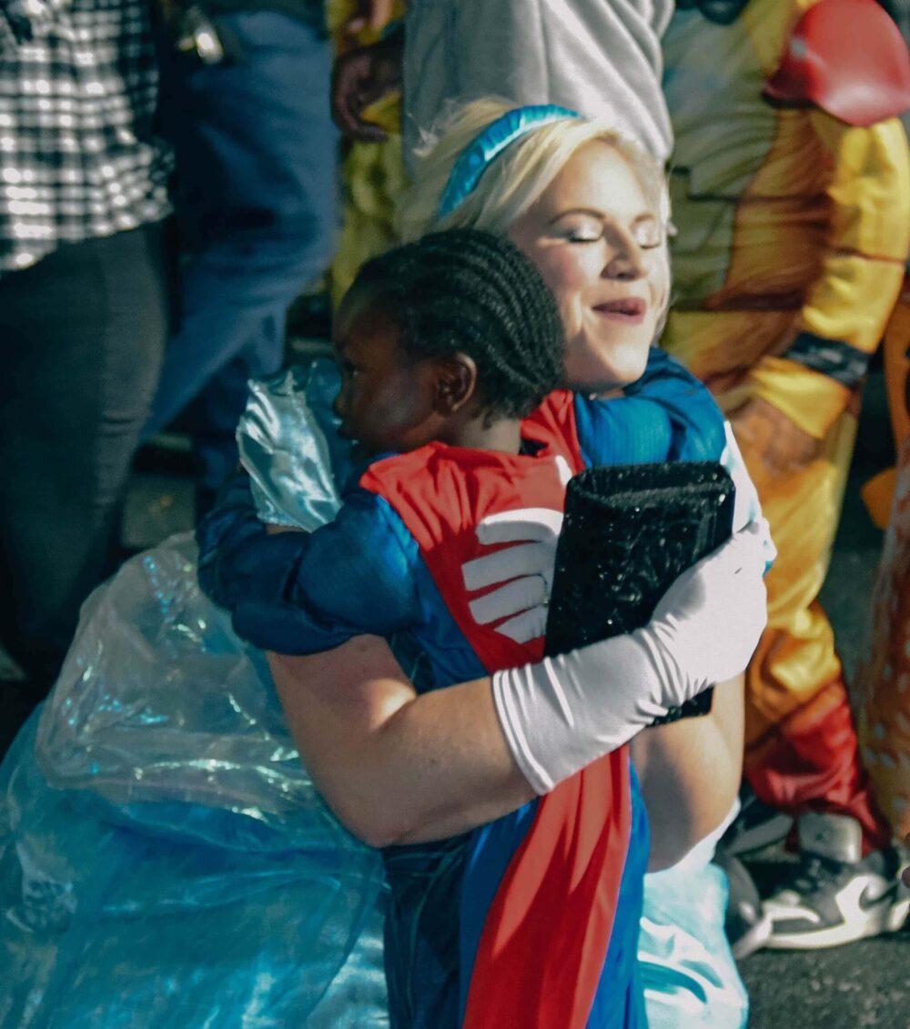 volunteer hugging a child at Trunk or Treat
