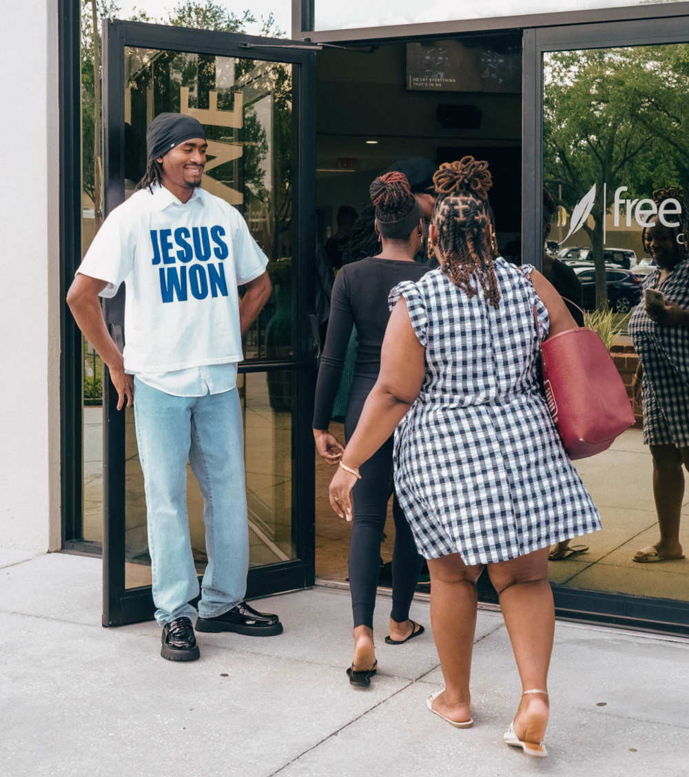young adult greeting and holding door at Free Life Chapel